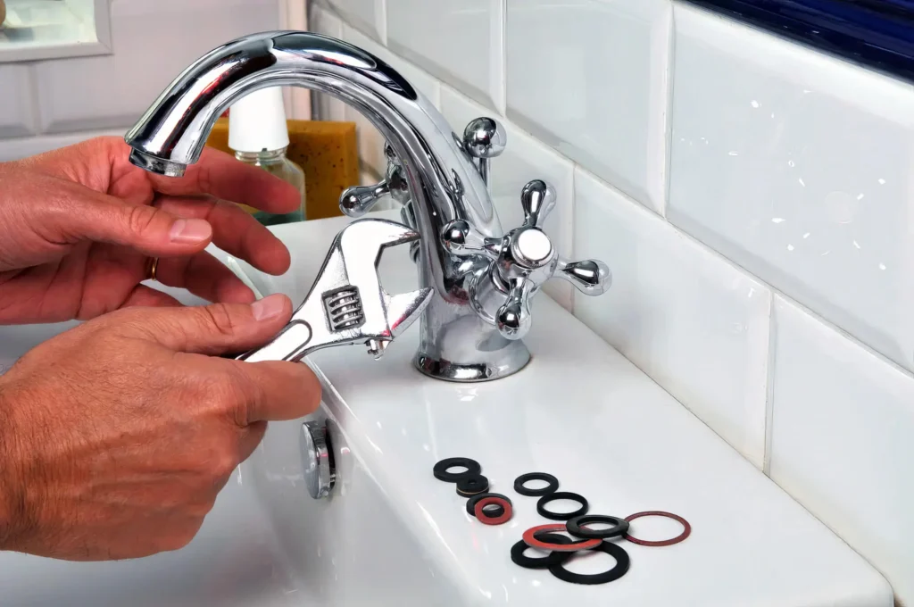 Plumber performing maintenance on a bathroom faucet in Palm Springs