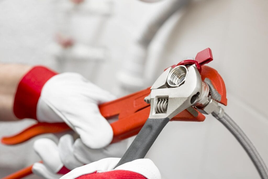 Plumber holding pipe wrenches for an emergency repair in Palm Springs