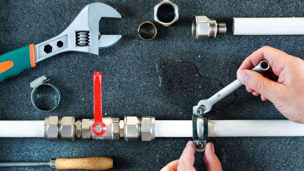 Plumber repairing a pipe valve with an adjustable wrench in Palm Springs