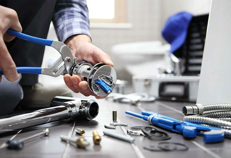 Technician repairing a plumbing fixture with professional tools in Palm Springs