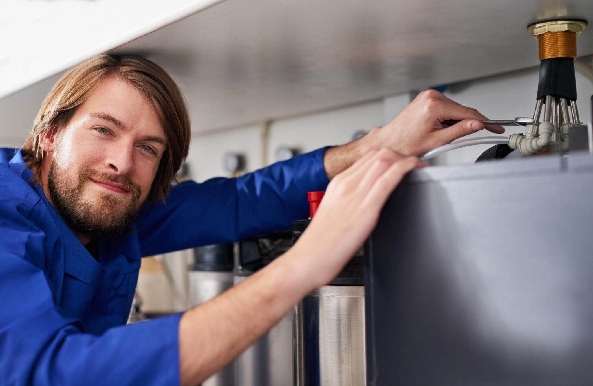 Technician servicing a residential water heater tank in Palm Springs