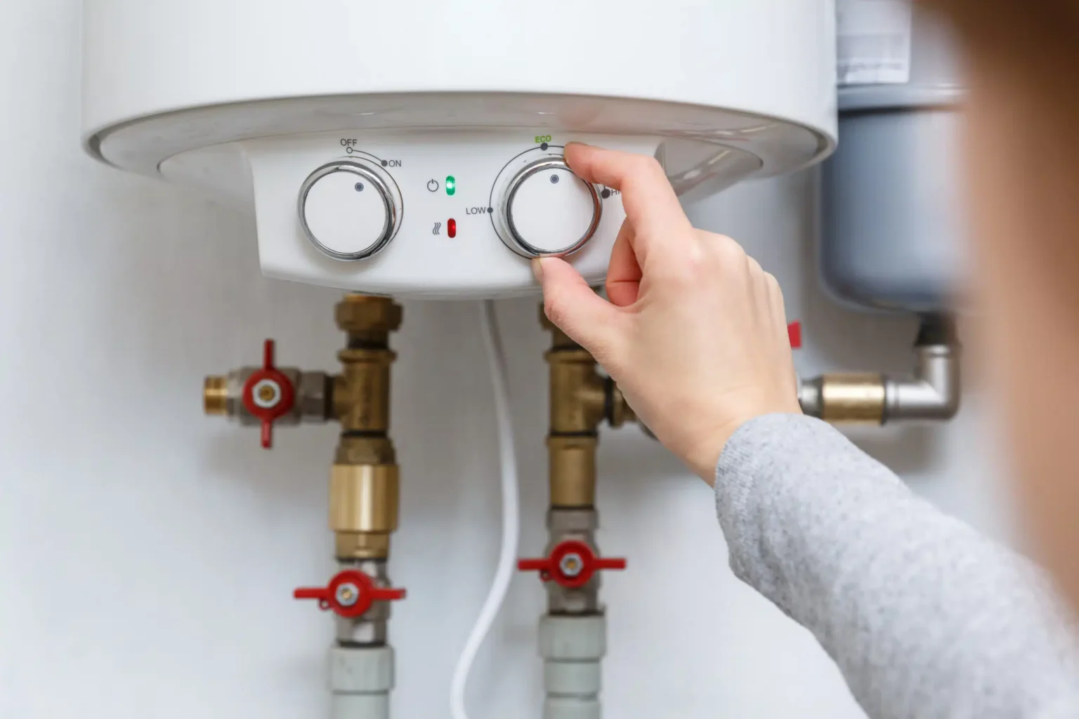 Homeowner adjusting the temperature controls on a water heater in Palm Springs